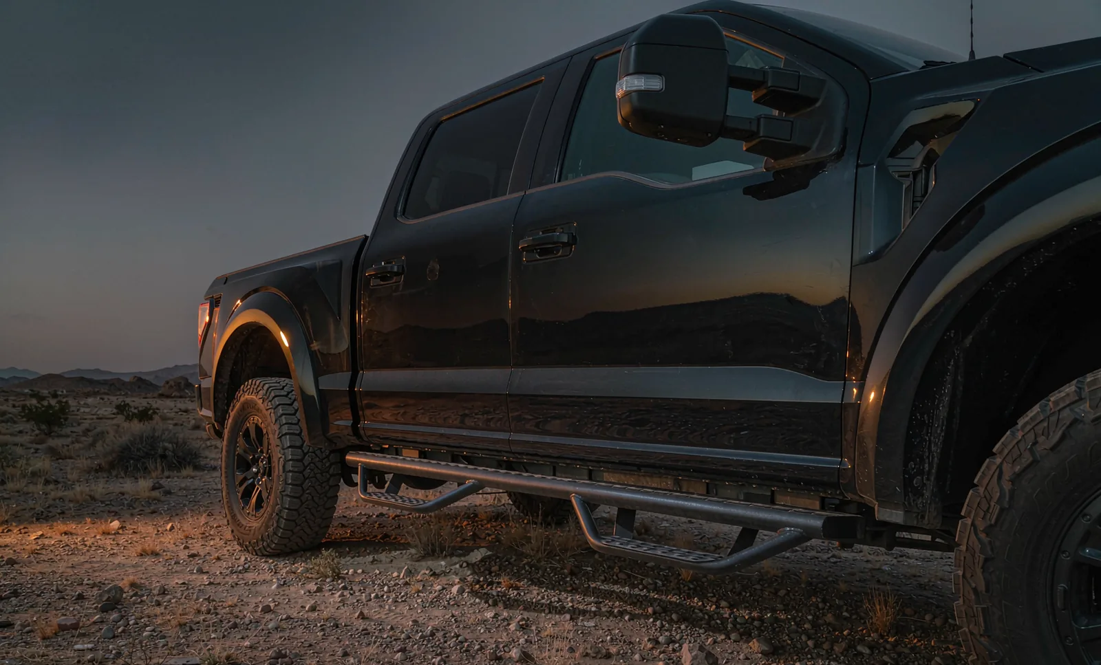 Black crew-cab pickup at dusk with six-inch stainless running boards along the rocker panel